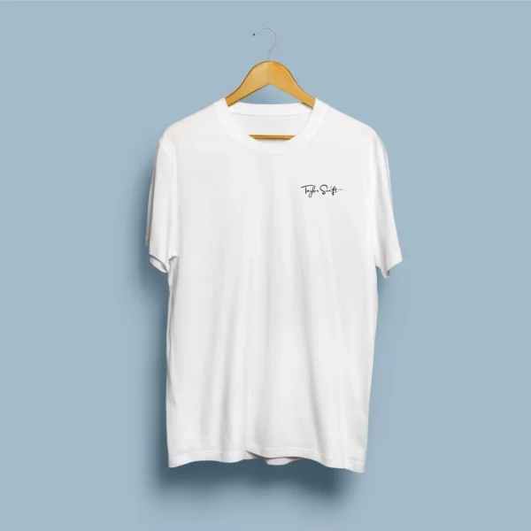 Frente de t-shirt branca com assinatura manuscrita Taylor Swift no peito esquerdo, em cabide de madeira