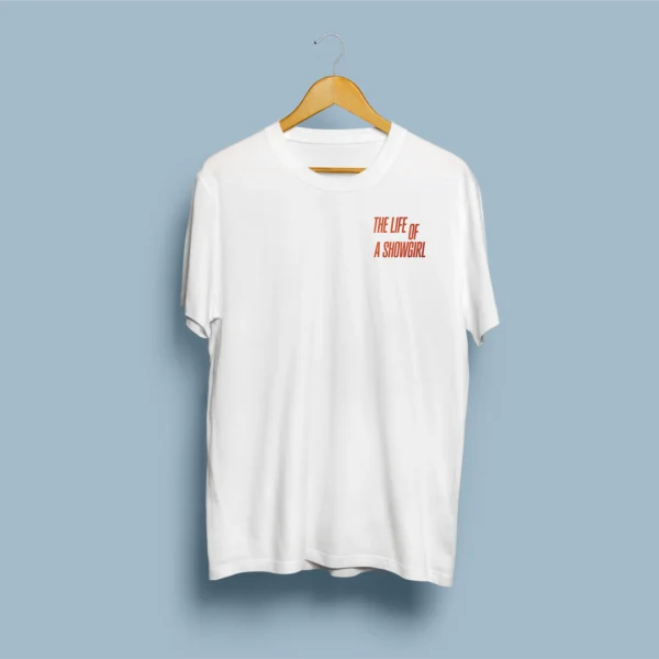 Página principal 11 Frente de t-shirt branca com tipografia THE LIFE OF A SHOWGIRL em vermelho/laranja no peito esquerdo